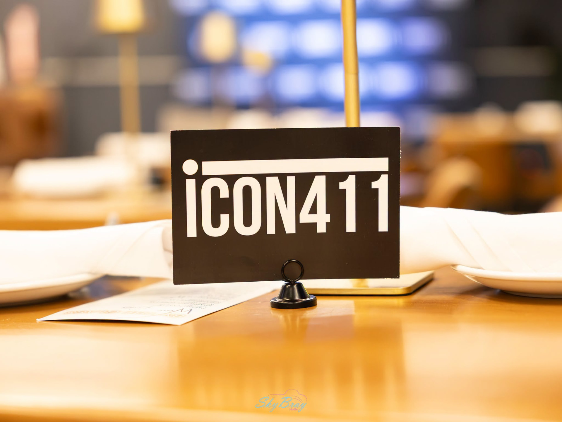 An Icon411 table card set on a venue table between napkins and plates