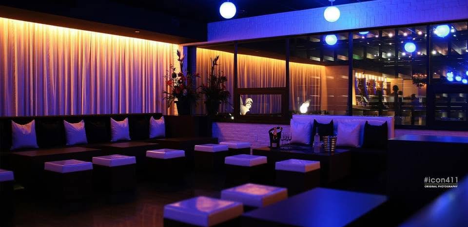 A lounge seating area with banquettes, low tables, and warm ambient lighting at a venue